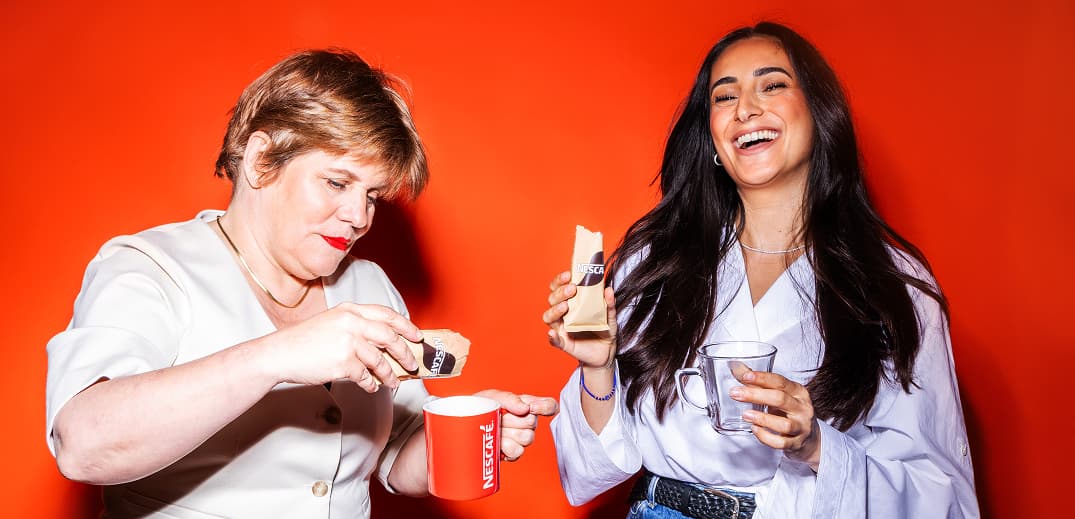 Two women against a vibrant orange background